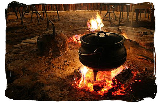 Cooking potjiekos (pot food)over an open fire, highly popular with all South Africa cultures - food in South Africa.