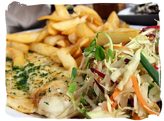 Kingklip with potato chips and salads - seafood cuisine in South Africa.