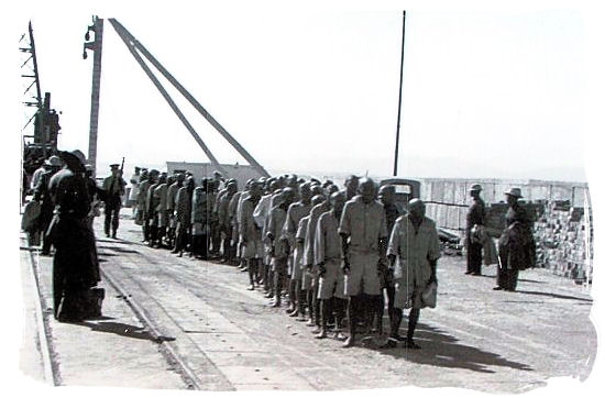Old prison photo showing prisoners after disembarkation, lined up to enter the prison - Amazing Robben Island tour, visit Nelson Mandela prison cell