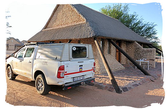 A rented 4x4 Toyota Hilux safari vehicle in front of a chalet in Twee rivieren camp in the Kgalagadi Transfrontier National park