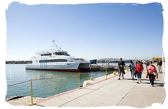 Tourists walking on the Robben Island quayside with the ferry in the background - Amazing Robben Island tour, visit Nelson Mandela prison cell